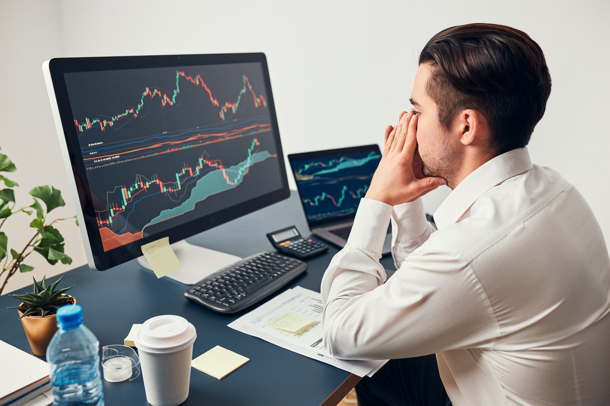 Worried businessman with weak trading psychology looking at charts stressed by news from stock market. Investor lost money online