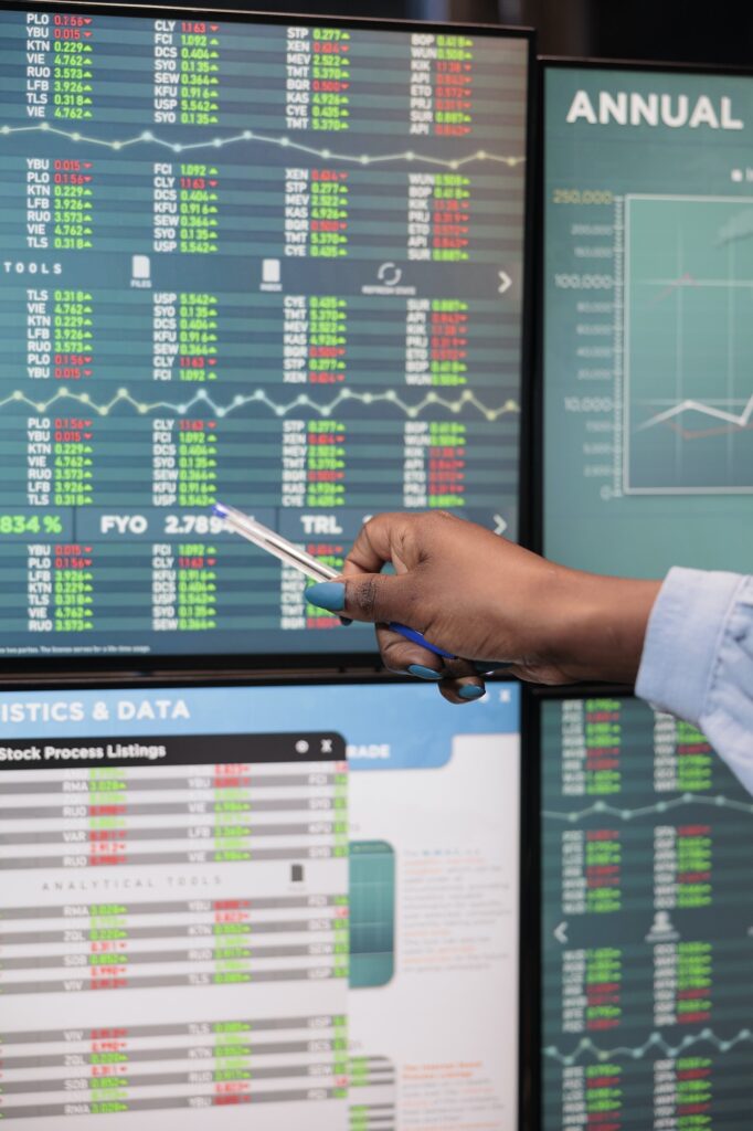 Close up shot of automated forex trading market trader woman pointing at screen showing real time trading data.